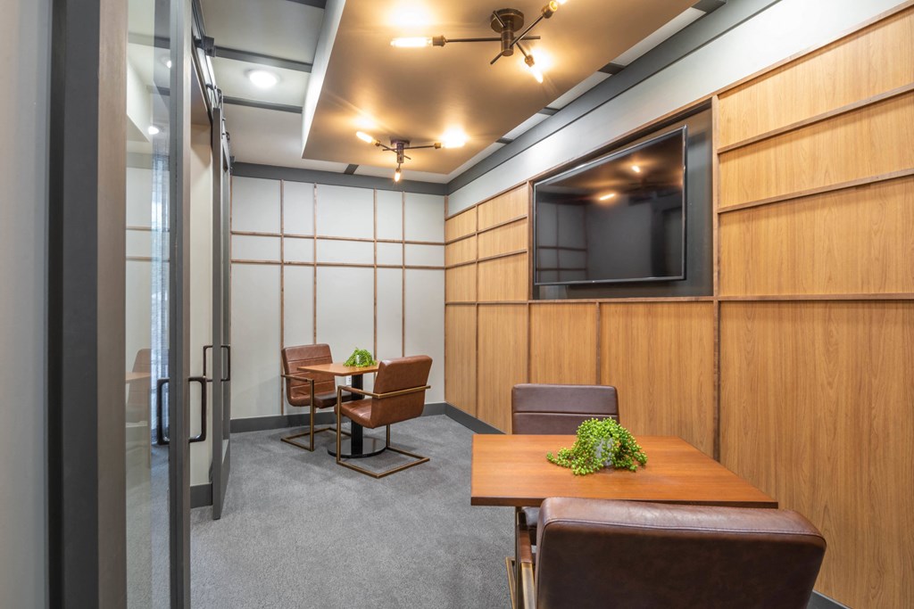 a conference room with a table and chairs and a television