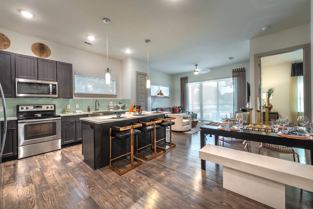 a kitchen and dining room with stainless steel appliances and wood floors