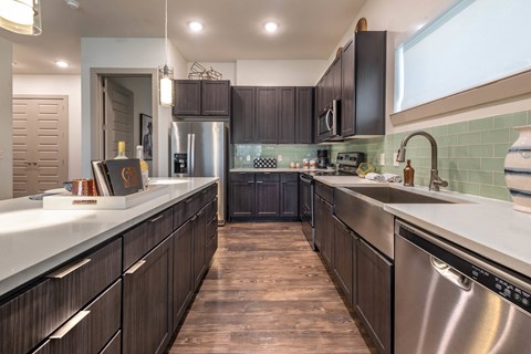a kitchen with stainless steel appliances and dark wood cabinets