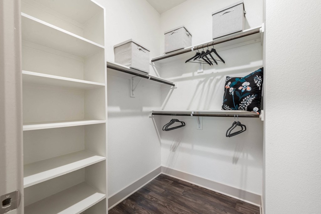 a walk in closet with white walls and shelves and