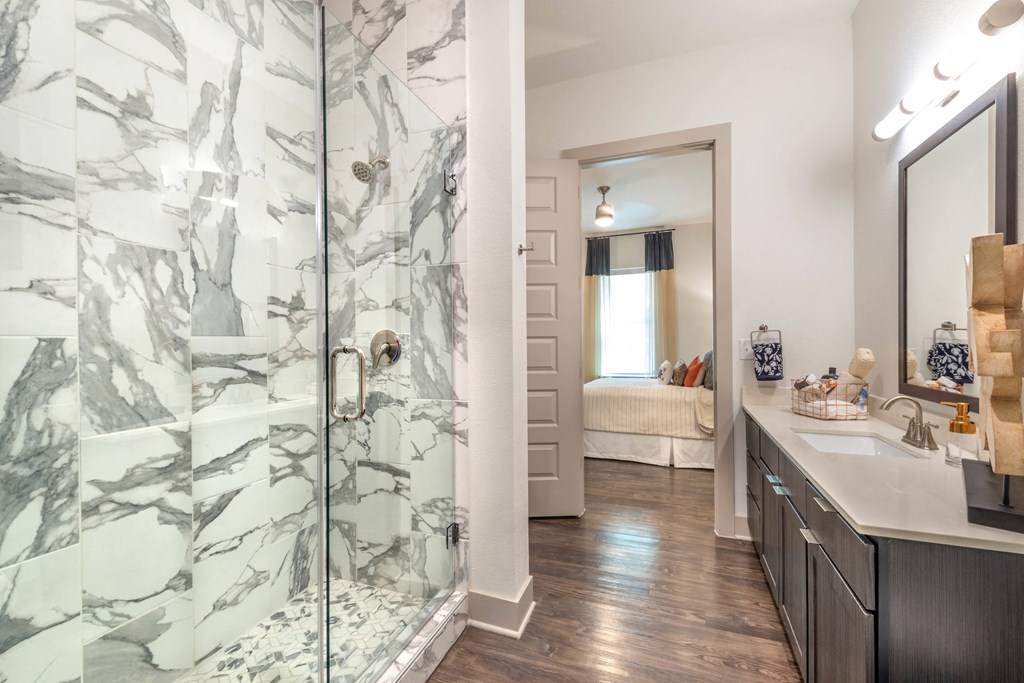 a bathroom with a shower and a sink and a mirror