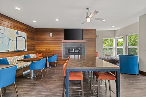 a living room with a large table and chairs and a fireplace at Allez, Redmond, WA 98052