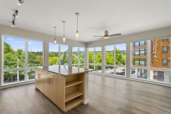 a living room with a large window and a large island with a countertop at Allez, Redmond, WA 98052
