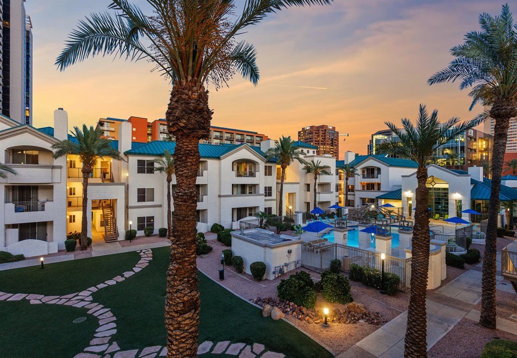 an aerial view of a resort with a swimming pool and palm trees