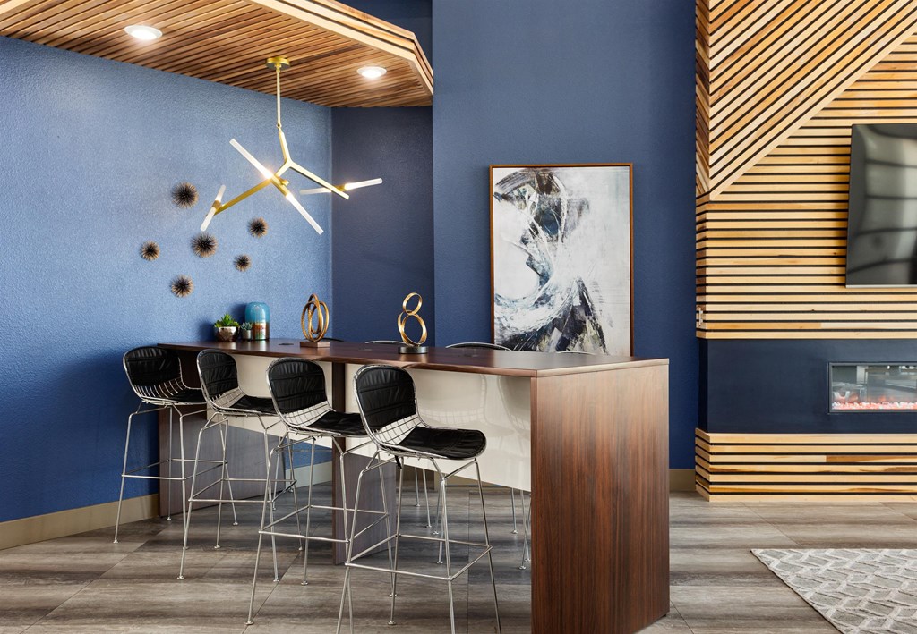 a dining room with blue walls and a large clock on the wall