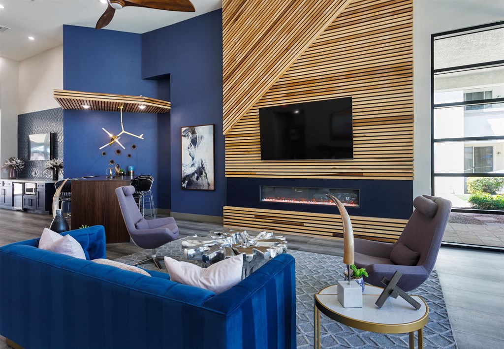 a living room with a blue couch and a fireplace