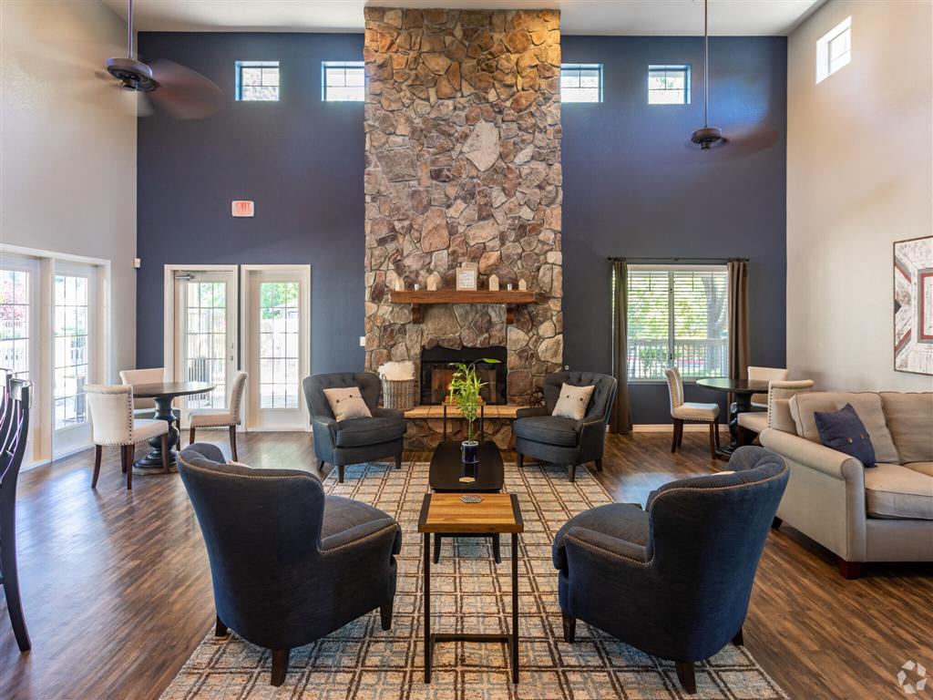 A living room with a stone fireplace and dark blue walls.