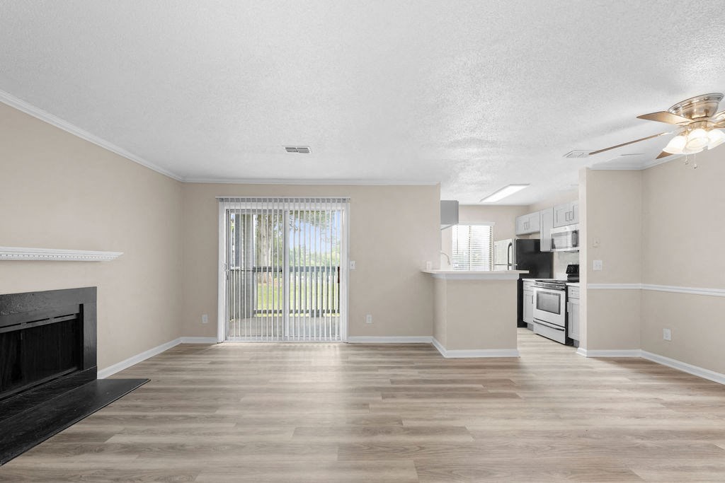 the living room and kitchen of a new home with wood flooring