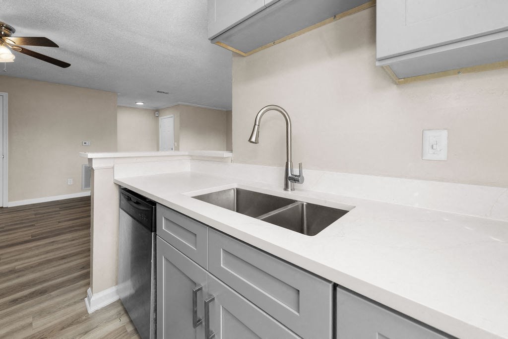 a kitchen with white counter tops and a sink