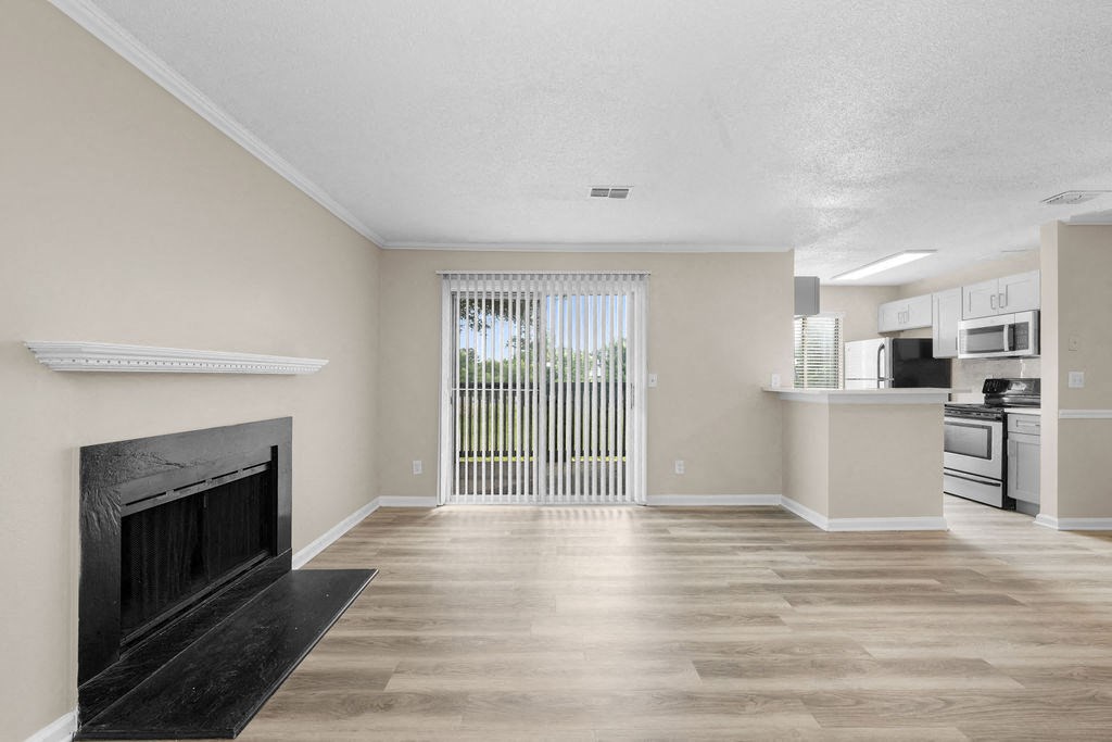 a living room with a fireplace and a kitchen