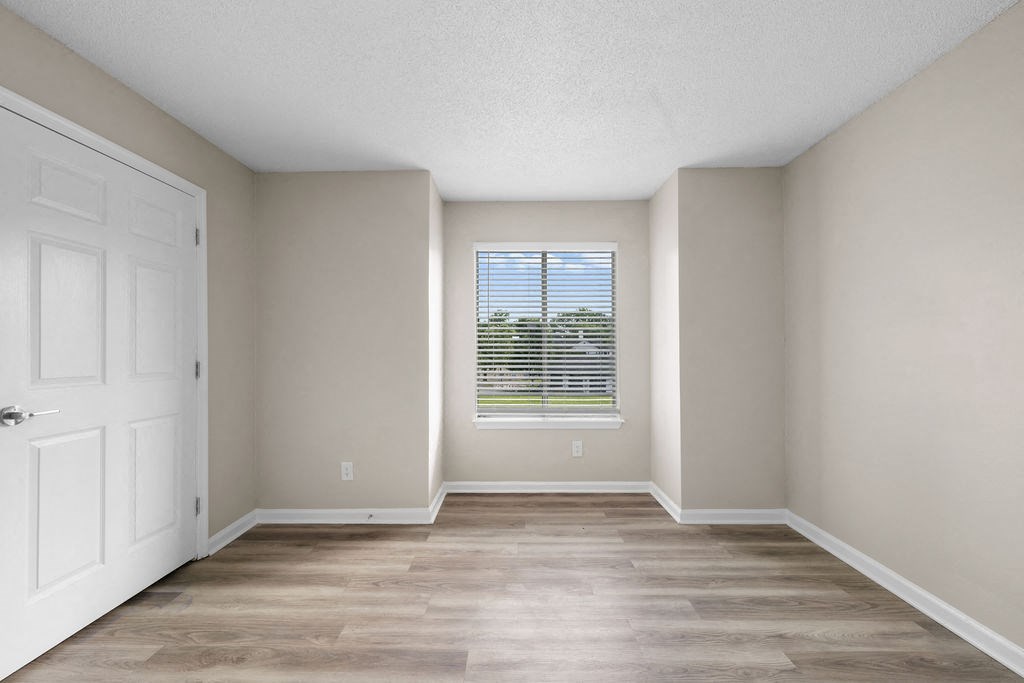 an empty room with a window and a white door