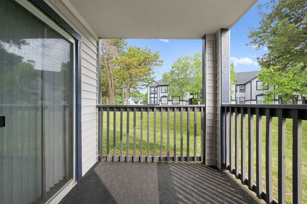 the view of a yard from a balcony with a glass door