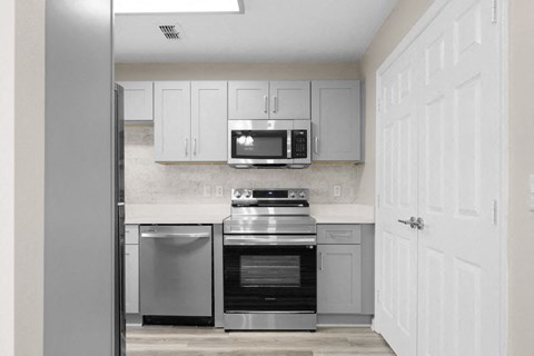 a kitchen with white cabinets and a stove and a microwave