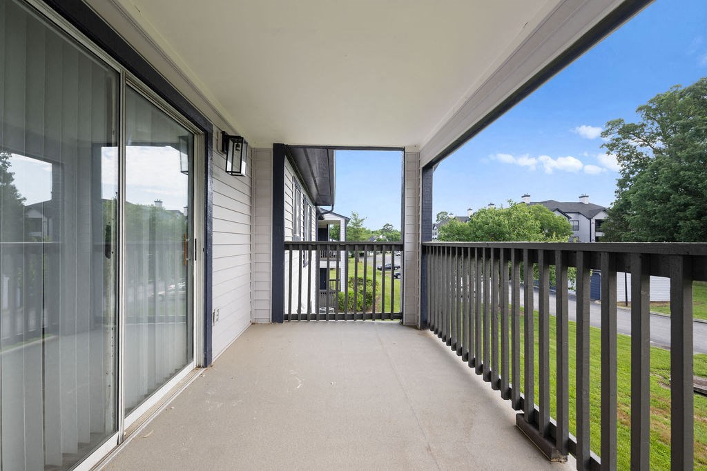 a large balcony with glass doors and a view of the yard