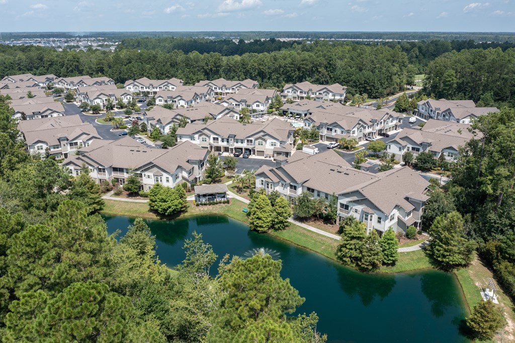 A bird's eye view of a residential area with houses and a lake.