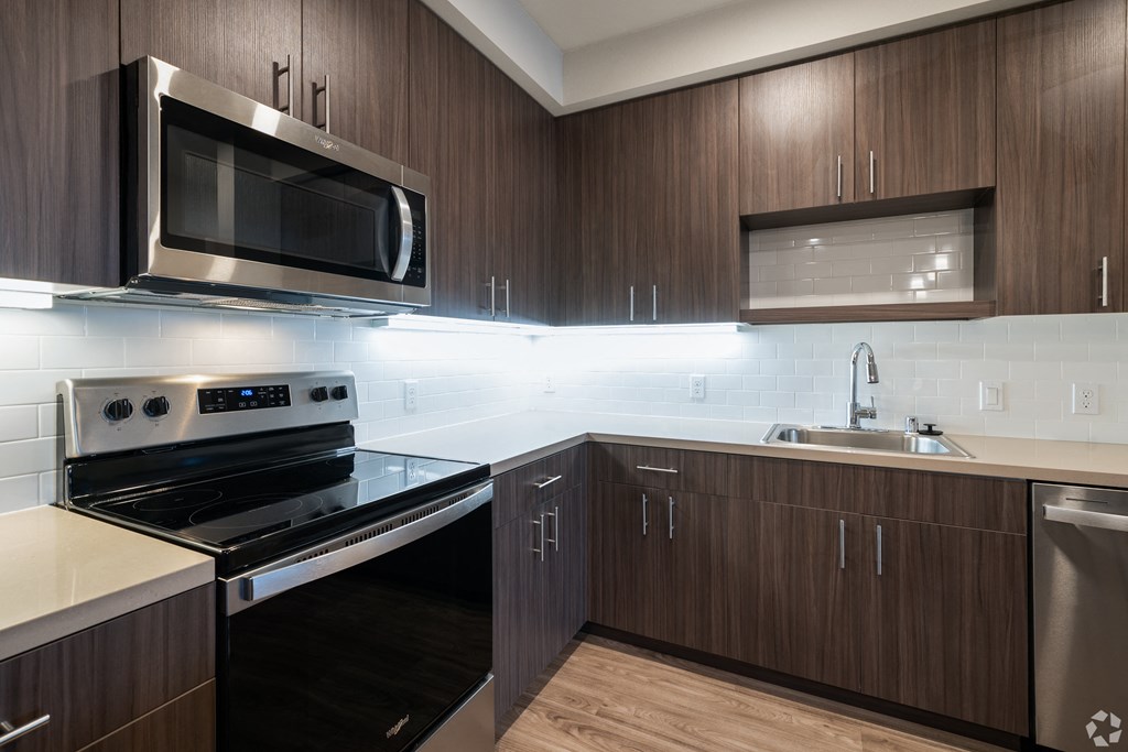 a kitchen with black appliances and wooden cabinets