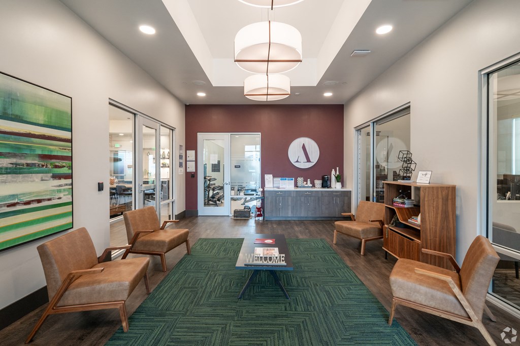 a lobby with chairs and a table and a reception desk
