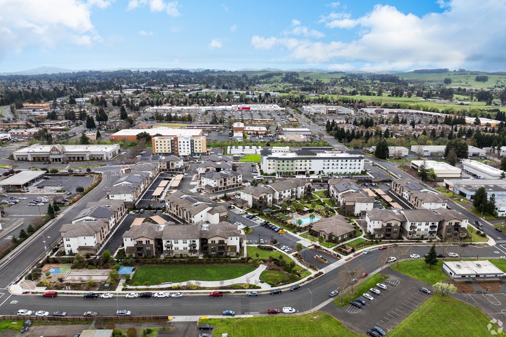 an aerial view of a city with cars parked in a parking lot