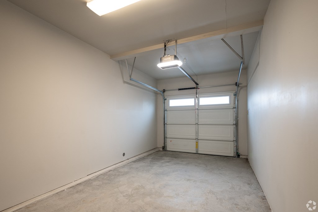 an empty garage with a white wall and a garage door