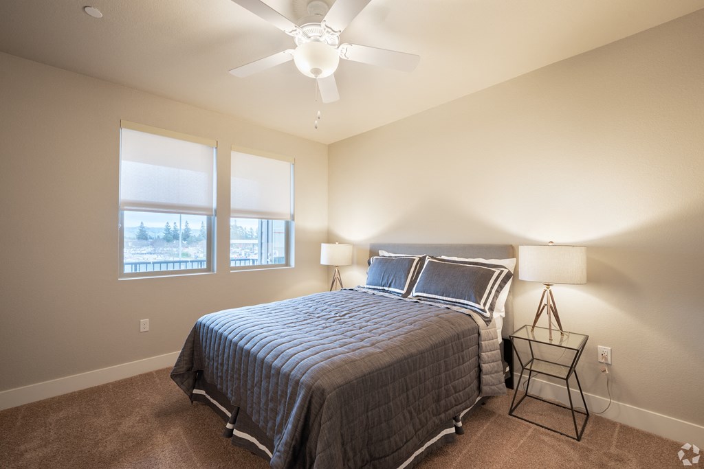 a bedroom with a large bed and a ceiling fan