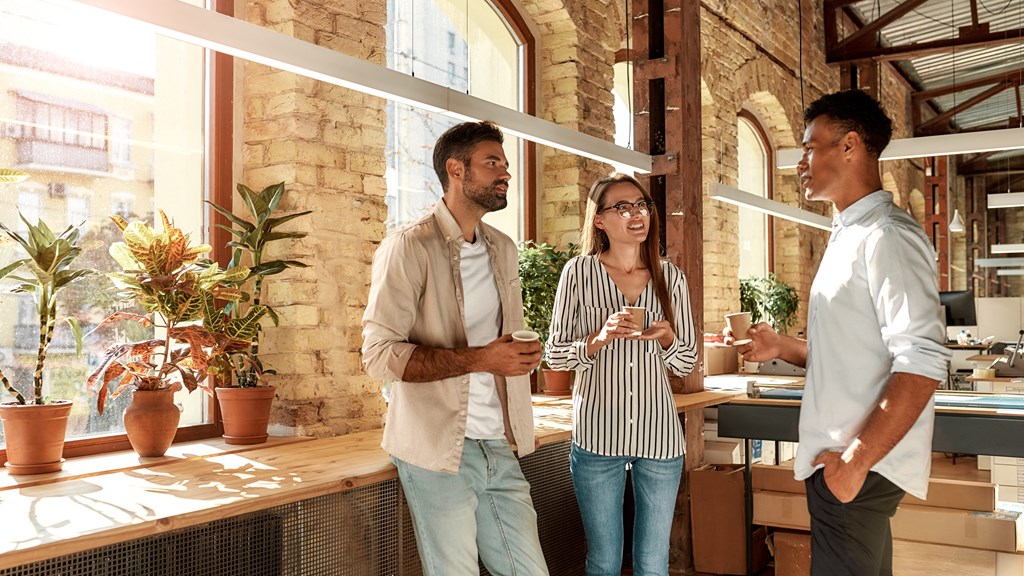 two men and a woman standing in a restaurant with drinks