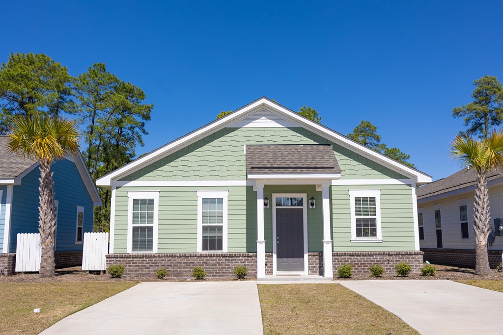 a green house with palm trees in front of it