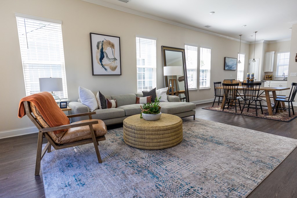 a living room with a couch and chairs and a rug