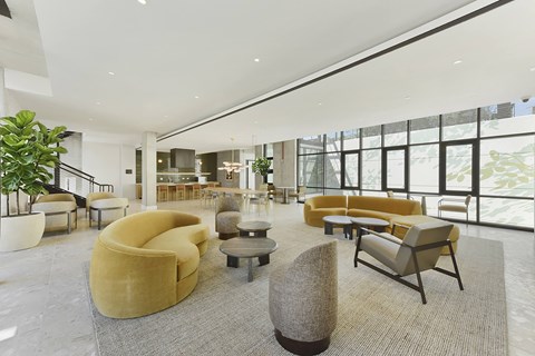 A large, modern living room with a variety of seating options and a large window.