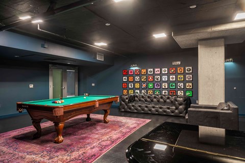 A pool table with a green cloth and a cue stick on it.