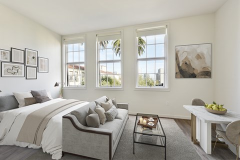 A bedroom with a bed, a table, and a painting on the wall.