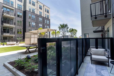 A patio with a table and chairs overlooks a building.