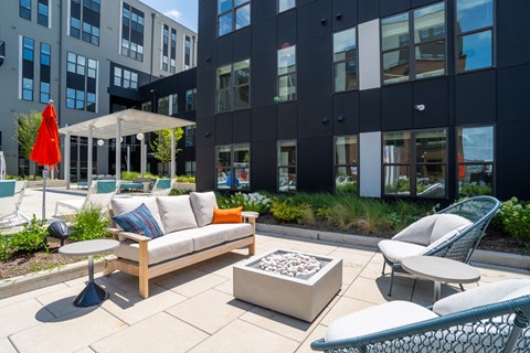 A patio area with a couch, chairs, and a table.