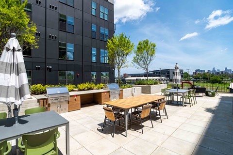 A patio with a table and chairs is in front of a tall building.