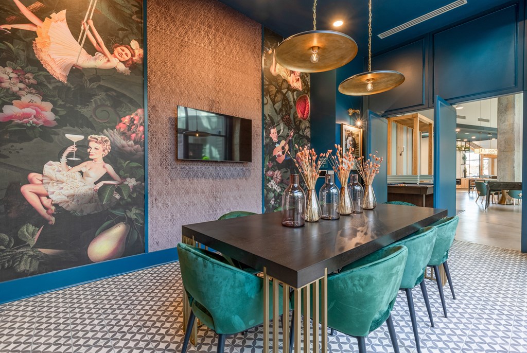 a dining room with blue walls and a table with gold chairs