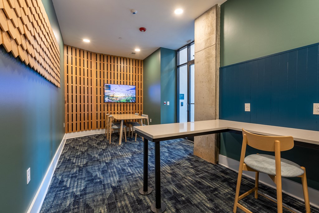 a conference room with a table and chairs and a television