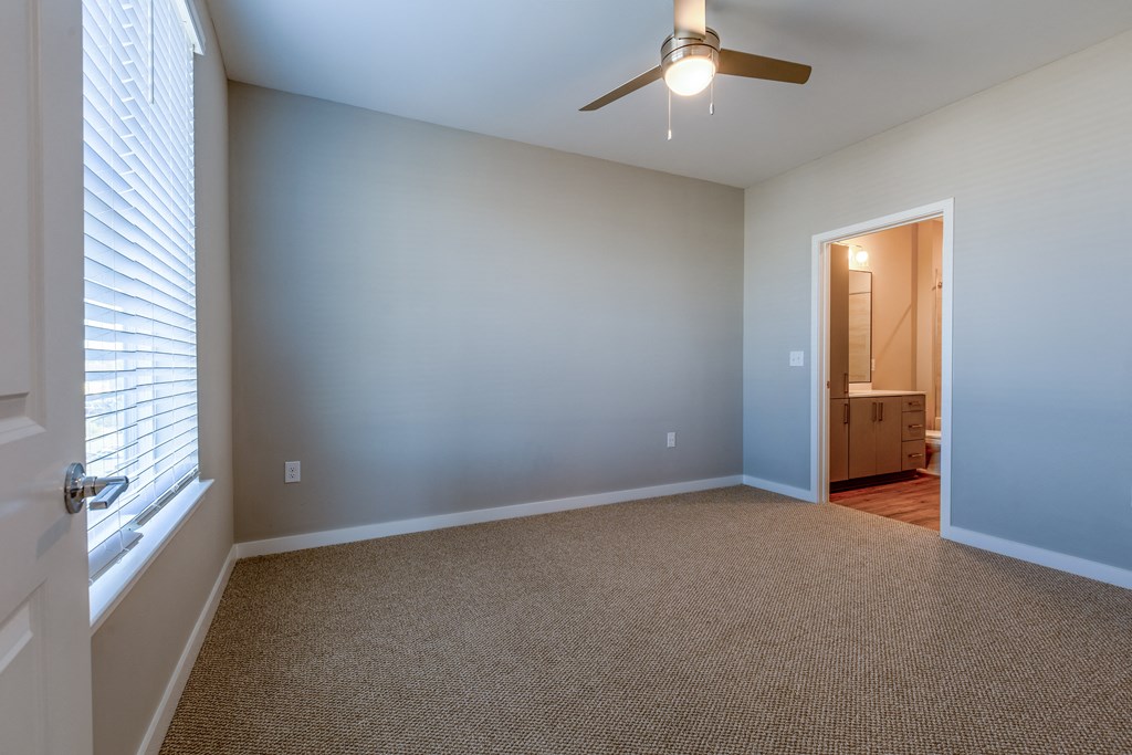 an empty living room with a ceiling fan and blue walls