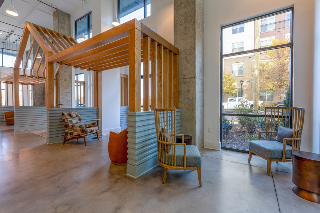 the lobby of a building with chairs and a wooden structure