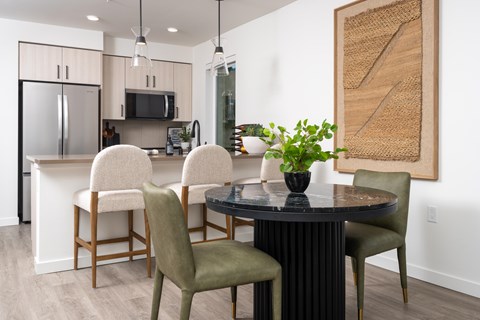 A modern dining room with a round table and chairs.
