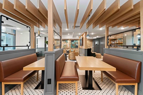 A restaurant with brown booths and wooden tables.