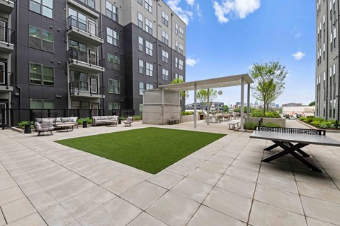 A patio area with a table and chairs is surrounded by apartment buildings.