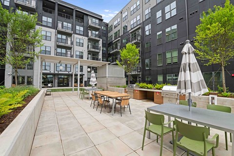 A patio with a table and chairs is surrounded by buildings.