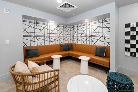 A room with a brown couch and a wicker chair.