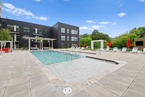 A pool area with a building in the background.