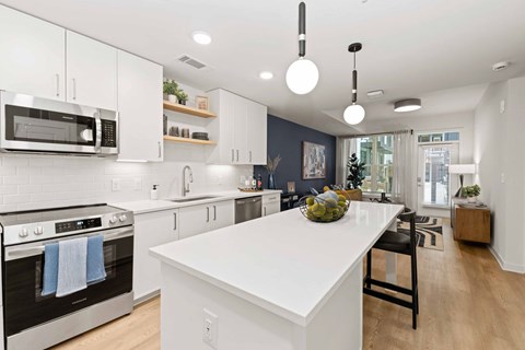 A modern kitchen with a white island and stainless steel appliances.