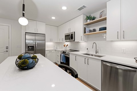 A modern kitchen with white cabinets and a stainless steel refrigerator.