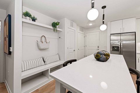 A white kitchen with a table and chairs.