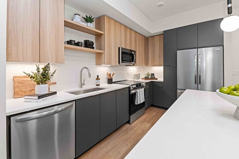 A modern kitchen with a stainless steel dishwasher and a refrigerator.