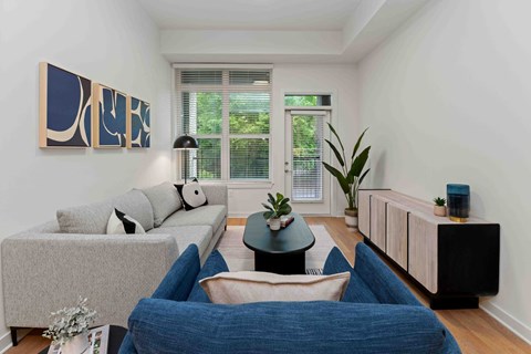 A living room with a grey couch, a blue chair, and a black table.