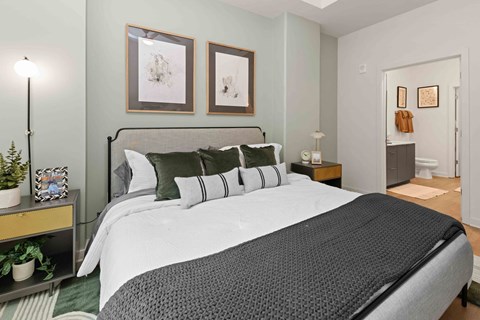 A bedroom with a large bed and two pictures on the wall.