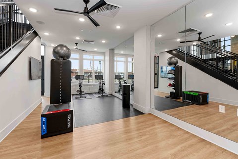 A spacious room with a black staircase and a wooden floor.
